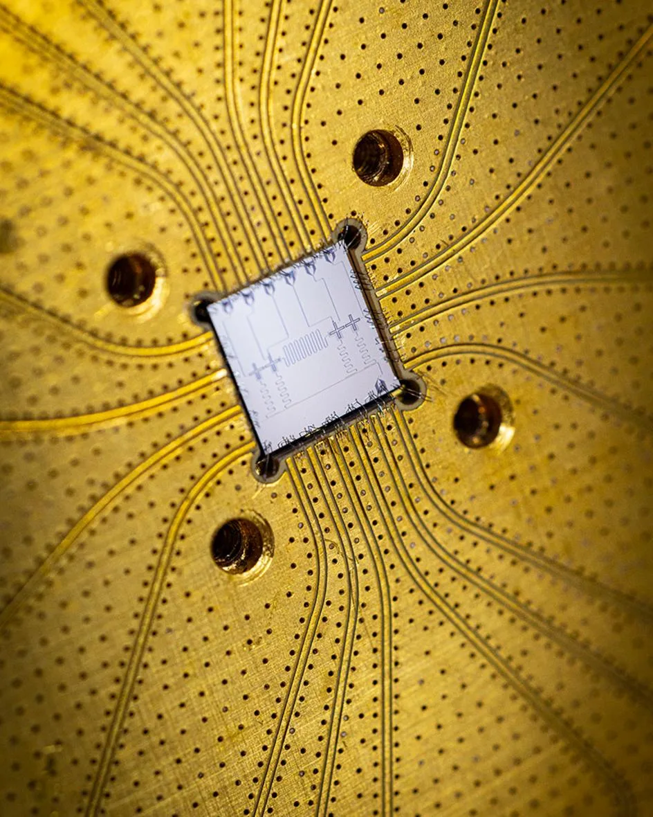 Superconducting qubit chip wire-bonded to a gold-plated circuit board, the hardware behind quantum computing.